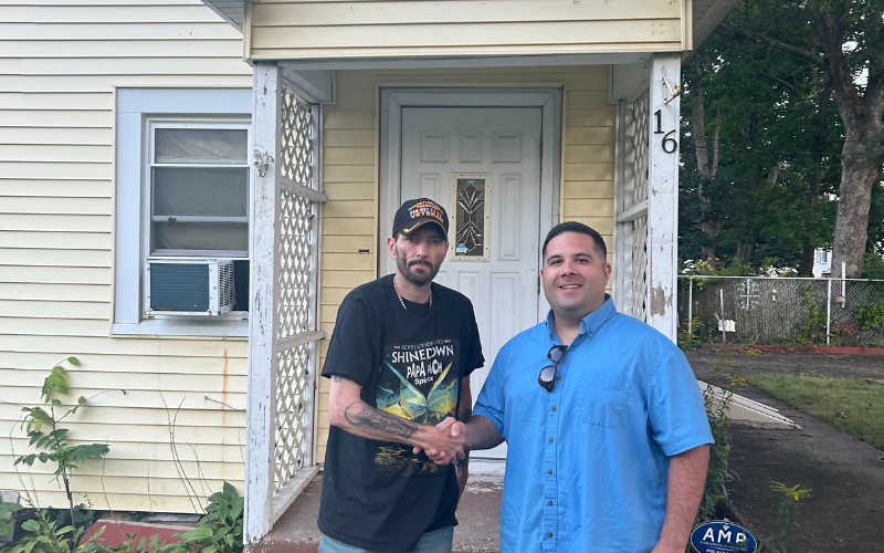 Mike Plactere shaking hands with a seller outside a Long Island house